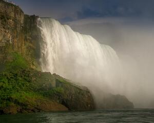 Niagara Falls from the base of the falls. showing the powerful water coming over the cliff above.