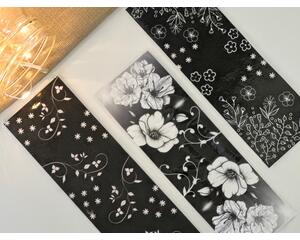 black and white floral bookmark set of 3 on a white table with a light brown table runner with fairy lights in a jar in the left-hand corner