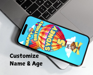 colorful hot air balloon with dogs in the basket, personalized happy birthday message with 5 (age) in yellow text against a clouded sky blue background on a cellphone