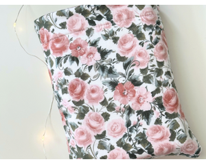 This floral book sleeve has a white background with pink flowers and dark green leaves
