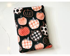 this pumpkin book sleeve has a black background with pumpkins having different prints on each pumpkin