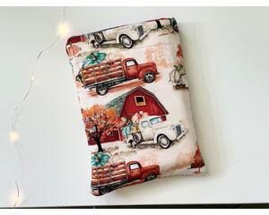 this fall book sleeve has a light brown background with farmhouse, truck filled with pumpkins and fall trees