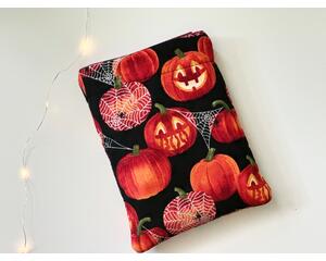 this pumpkin book sleeve has a black background with some pumpkins having sparkly spider web, some are carved and others are not