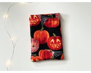 this pumpkin kindle sleeve has a black background with some pumpkins caved out and others covered in sparkly spider web