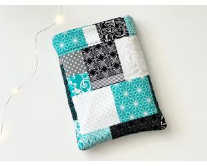 this patchwork book sleeve has blocks of black, gray, white and blue each block having different prints