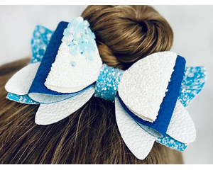 My 4 year old modeling a blue and white glitter 4 layer bow. Top left corner of bow has dripping iridescent blue rhinestones.
