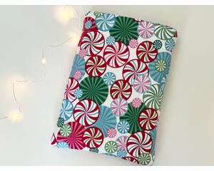 This Christmas book sleeve has a white background red, pink, blue & green hard candy