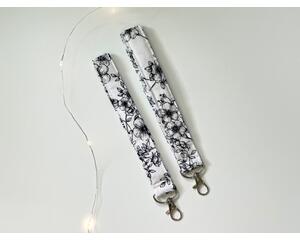 this floral keychain wristlet has white background with black florals