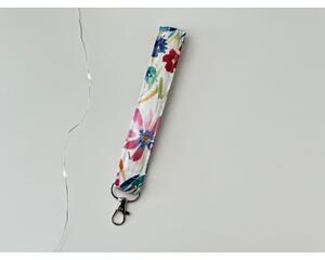 this floral keychain wristlet has a white background with colorful flowers