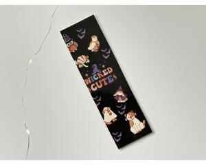 this Halloween bookmark as a black background with the words 'Wicked Cute' in the middle animals dressed up in Halloween costumes, and little bats flying
