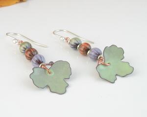 Super cute autumn earrings. Celebrate fall with these sweet dangles which have three teeny tiny copper enamel pumpkins of pastel green, orange, and lavender, with a pale green leaf swinging below. Super lightweight, slightly elegant yet easily blends with any attire.