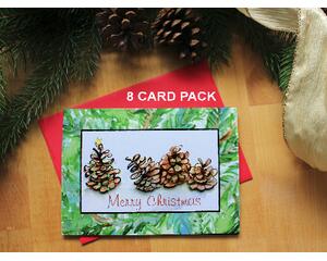 Merry Christmas card adorned with 4 quirky watercolor pine cones sitting in a row.  The one on the left is decorated like a Christmas tree. 