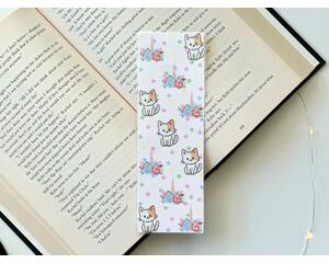 this cat unicorn bookmark has a light pink with pastel small stars in the background. There are cars and flower unicorn crowns all over