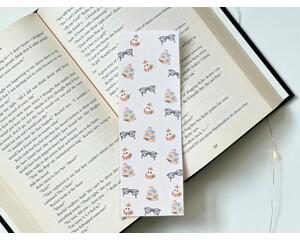 This bookish owl bookmark has a light brown background with little stars in the background. The page saver has book stacks, glasses and owls covering the bookish book mark