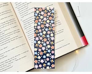this floral bookmark has a navy blue background with small white polka dots & flowers (white, orange, yellow, pink, purple) and bees all over the bookmark