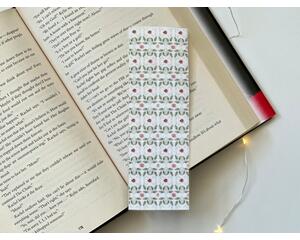 this elegant bookmark has a white background with small green leaves and light and dark pink roses all over the book mark