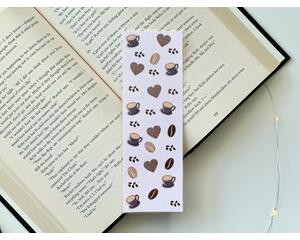 this coffee bookmark has a light purple background with medium coffee beans small and some making a heart shape. there are purple coffee cups all over the coffee bean page saver