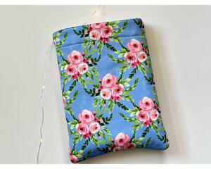 this floral book sleeve has a blue background with pink roses and green leaves all over the book holder