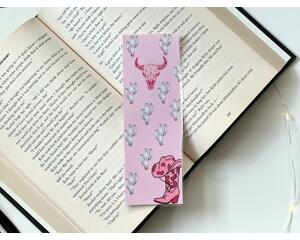 this pink western bookmark has a pink background. with a pink bull in the middle & a pink cowboy boot with a hat on top in the bottom right 
