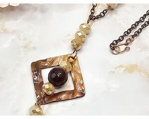 square washer style flame colored copper pendant with purple quartz and cream colored crystal beads on copper chain with hook clasp