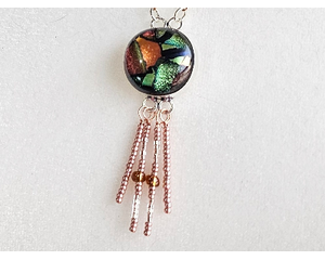 Dichroic glass pendant: metallic hues of copper, green, red with copper seed beads on wire dangle from the bottom of pendant on copper chain