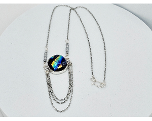 Dichroic glass: metallic blue, green, yellow hues with 3 silver chains dangling from underneath on silver chain with hook clasp