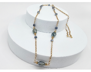 long necklace on gold chain with blue oval shaped crystals, smaller blue round crystals, and gold round beads with a gold hook clasp