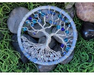 stunning 3 inch tree of life featuring clear glass and a variety of blue glass beads attached to blue yarn wrapped hoop