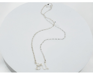 silver necklace with handcrafted wire letters "B" and "U" connected on a delicate silver chain, symbolizing "Be You."