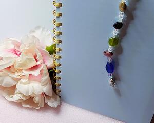 Multi color glass and clear faceted crystal beaded bookmark with a silver tone dragonfly charm at the end. Measures 12" in length.