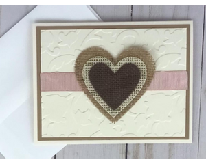 A wedding card with cream embossed cardstock, a tan cardstock mat, a handcrafted burlap heart embellishment and a rose pink ribbon.