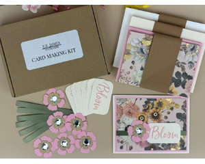 Card making kit with gold foil floral patterned scrapbook paper, pink cardstock, pink flowers, green ribbons and off-white Bloom sentiments.