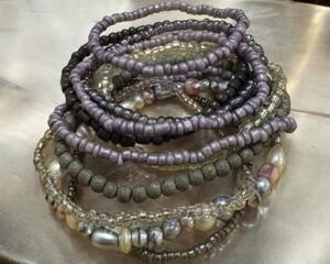 this handmade beautiful ten stack bracelet is purple and lavender glass beads. It is stretchy.
