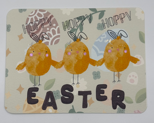 Yellow chicks wearing bunny ears and shiny pink cheeks accented with paint with Easter spelled out in chocolate 