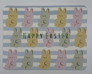 Watercolor marshmallow bunnies in pastel pink, yellow, green on blue and white striped background with happy Easter across card