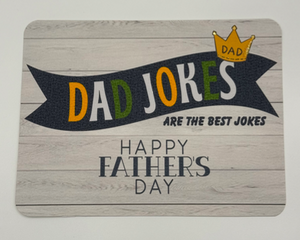 Father’s Day card for the jokester of the family, text reads dad jokes are the best jokes on background of white washed wood and crown 