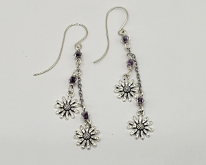 Handmade 2.5 inch dangle earrings with violet swirl crystal beads and silver daisy flower charms on delicate chains.