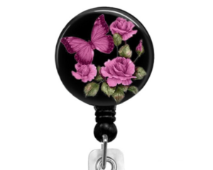 Butterfly and pink roses on a black background affixed to a retractable badge reel.