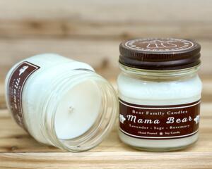 Lavender and rosemary scented soy candle in 8oz mason jar. One jar standing up with lid on and one jar on its side with lid off.