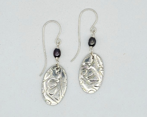 Handmade 2-inch dangle earrings with textured pewter oval drops and small freshwater pearl beads on argentium silver hooks.