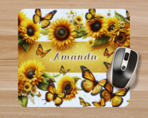 Close up of a personalized sunflowers and yellow butterflies mouse pad with a computer mouse on top. Created by Tammi Oribello Designs.