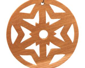 A handmade wooden Christmas tree ornament, circular in shape, crafted from light brown wood with a natural grain pattern. It features an intricate, symmetrical cutout design resembling a star or snowflake, with multiple pointed shapes radiating from a central hole. The ornament is attached to a small metal hook for hanging, showcasing its rustic and festive craftsmanship.