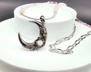 Handmade necklace with silver crescent moon pendant with rose quartz bead set inside a rose. Strung with rose quartz and pink crystal beads.