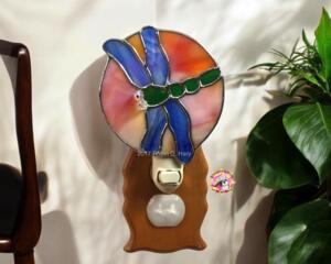 Dragonfly Stained Glass Night Light- in green and blue iridescent glass with yellow, orange mottle glass backdrop.
