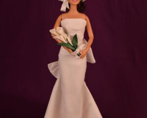 11.5 inch fashion doll wearing white sheath style wedding dress, birdcage veil and holding a bouquet of white lillies
