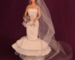 Mermaid style wedding dress, veil, and purple bouquet.