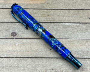 Blue titanium rollerball pen made with cast flowers in clear blue resin 