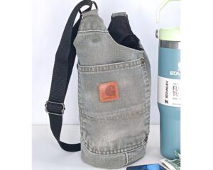 Upcycled Carhartt canvas water bottle sling shown beside Stanley tumbler and essentials.