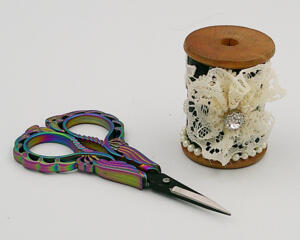 This view shows the 2 inch high wooden spool and her embellishment, The multicolored scissors are 4 inches long and included.