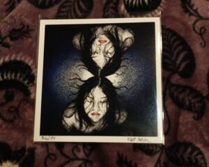 a 5 inch by 5 inch print of a pen drawing of a face and it's mirror image connected at the top of the head before a field of blue static.